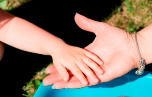 Barnehånd i dagplejers hånd